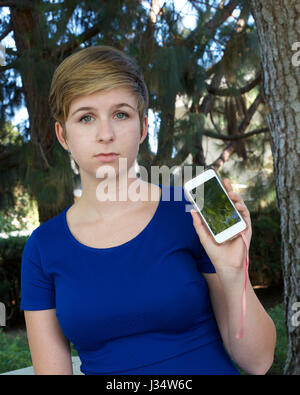 Parution de l'image modèle young caucasian teenage girl holding triste téléphone cassé Banque D'Images
