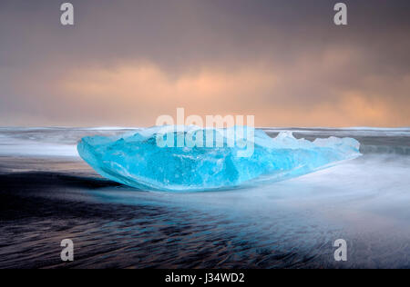 - L'ISLANDE JOKULSARLON, vers mars 2015 : Iceberg sur le sable plage noire près de la lagune de Jökulsárlón en Islande sur le bord de National Vatnajökull Banque D'Images
