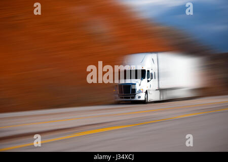 Gros blanc camion semi-remorque sur la route avec les lignes de démarcation jaune sur fond de couleur floue Banque D'Images