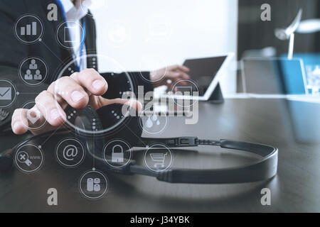 L'homme à l'aide de VOIP casque avec ordinateur portable et tablette numérique comme la communication concept,elle,support centre d'appels et customer service help desk avec vir Banque D'Images