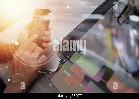 Businessman working avec téléphone mobile et tablette numérique et un ordinateur portable sur un bureau en bois dans un bureau moderne avec l'icône virtuelle schéma électrique Banque D'Images