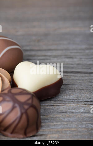 De délicieux bonbons de chocolat sur fond de bois Banque D'Images