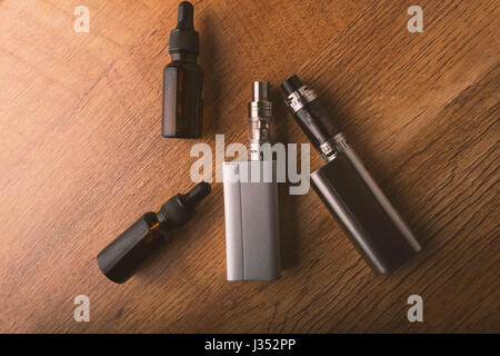 E cigarette avec e bouteilles pour liquides vaping périphériques, cigarette électronique ecigarette ou sur un fond de bois. Banque D'Images