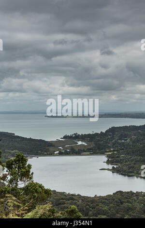 Auckland, Nouvelle-Zélande - 2 mars, 2017 : Nihotupu avec réservoir d'eau à l'arrêt Grand Bay sous un ciel gris foncé. Forêt autour du lac, beaucoup de gris Banque D'Images