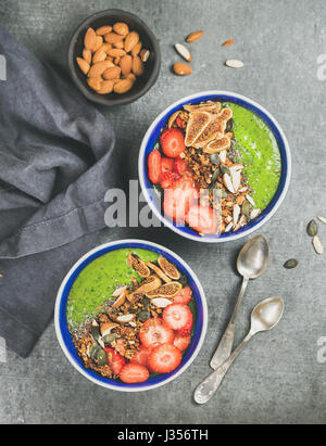 Bols petit-déjeuner smoothie vert sain avec des céréales, fruits, graines, amandes Banque D'Images