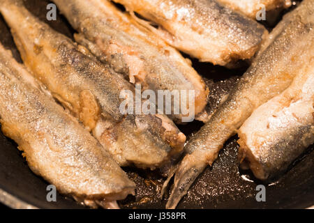 Les petits paniers de poissons sauvages d'or dans les rangées, frit dans une casserole, recouvert d'une délicieuse croûte dorée. La friture de poissons - une excellente alimentation nutritive Banque D'Images