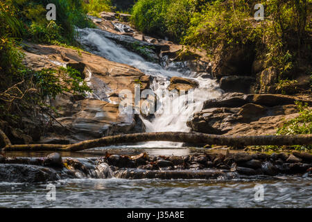 Cascade dans la jungle tropicale en Thaïlande, l'eau jaune vert Banque D'Images