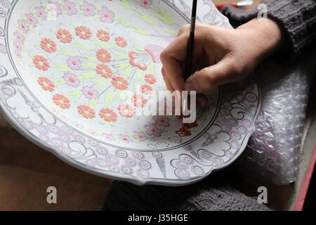 Kutahay, Turquie. Apr 25, 2017. Un artiste peint sur une base Cini dans une usine en Kutahay, Turquie, le 25 avril 2017. Cini est une sorte de faïence traditionnelle de l'industrie de la poterie qui a été original à partir de la Chine et est devenu mûri au cours de la période ottomane. En langue turque, Cini signifie "de Chine". Depuis 1950, la production Turque Cini a été industrialisé et combinée avec la vie quotidienne, qui a rapidement accru sa part dans le marché de la céramique. Credit : Qin Yanyang/Xinhua/Alamy Live News Banque D'Images