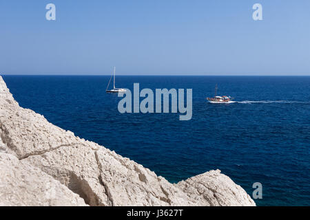 Kolymbia avec la côte rocheuse en Grèce. Bateau à moteur et de la vitesse dans une mer bleue. Banque D'Images