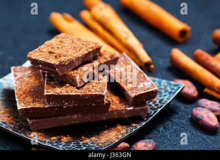 Le chocolat à la cannelle sur la plaque et sur une table Banque D'Images