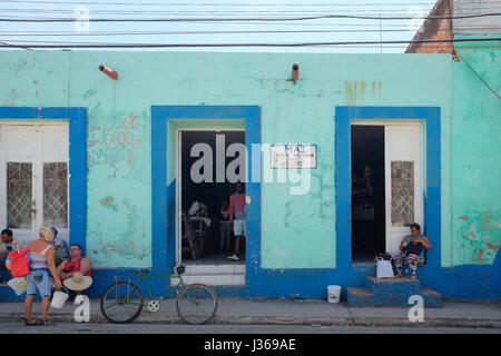 La vie de rue locaux à Trinidad, Sancti Spiritus, Cuba. Rassemblement de personnes en face d'une boutique. Banque D'Images