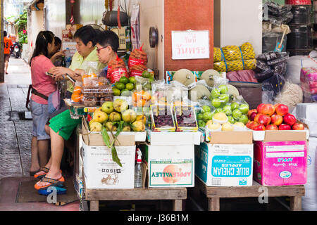 Les vendeurs de téléphones portables par les femmes sur leur étal de fruits de rue dans le quartier chinois, Bangkok, Thaïlande Banque D'Images