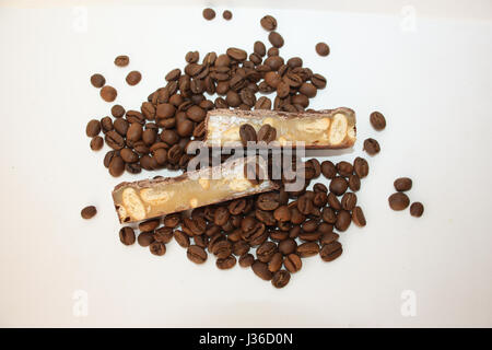 Bonbon sucré dans les fèves de café sur un fond blanc Banque D'Images