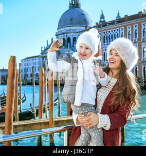 Un autre monde. vacances élégant sourire la mère et l'enfant les touristes à Venise, Italie au cours de l'hiver photo prise avec appareil photo numérique Banque D'Images