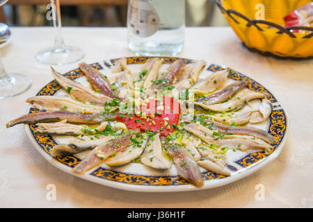 Anchois marinés à l'ail, le persil, le poivron rouge et l'huile d'olive. L'Espagne. Banque D'Images