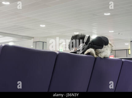 Jeune homme portant des écouteurs à l'aéroport de départ. Banque D'Images