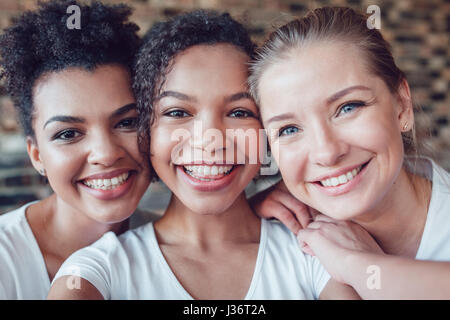 Agréable et amusant in white T-shirts selfies fait. Deux afro-américains et un européen. Banque D'Images