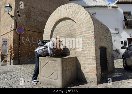 Femme buvant de l'eau publique fontaine dans Grenade Espagne Banque D'Images