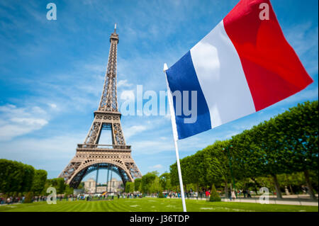 Drapeau tricolore dans le ciel bleu par un beau jour de printemps, en face de la Tour Eiffel à Paris, France Banque D'Images