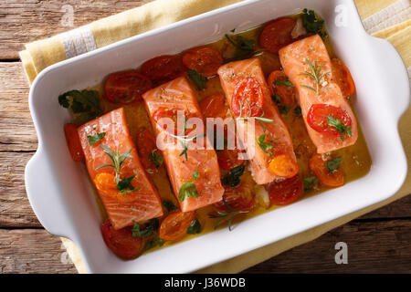 Mijoté de saumon et les tomates cerises dans l'huile d'olive dans un plat allant au four. Gros plan Vue de dessus horizontale Banque D'Images