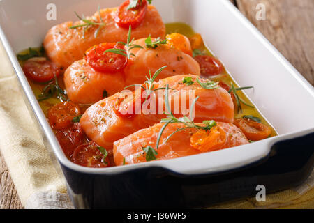 Mijoté de saumon et les tomates cerises dans l'huile d'olive dans un plat allant au four, libre. L'horizontale Banque D'Images