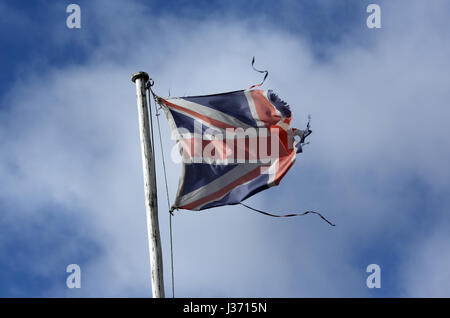 Un drapeau en lambeaux dans le vent sur la photo contre un ciel nuageux ciel bleu d'un mât en Ecosse Ballater Banque D'Images