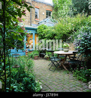Jardin arrière avec table et chaises. Banque D'Images