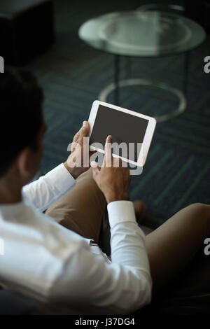 Businessman using digital tablet while sitting at office Banque D'Images