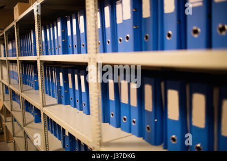 Blue dossiers classés sur les étagères dans la salle de stockage Banque D'Images