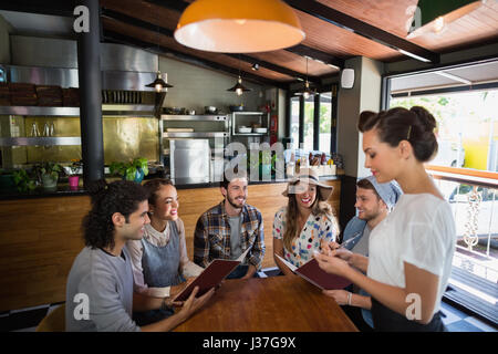 Jeune serveuse en prenant les commandes des clients dans le Banque D'Images