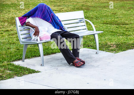 Miami Beach Florida,Lummus Park,banc de parc,Black man hommes,dormir,visage couvert,tête,couverture,cacher,maladie mentale,sans-abri,adolescent adolescent adolescent adolescent Banque D'Images