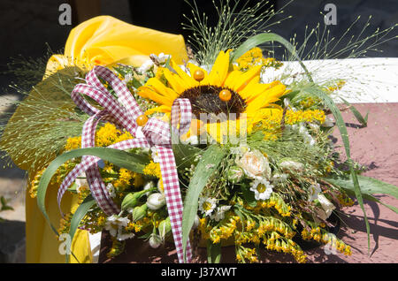 Décoration avec des fleurs. Bouquet de roses, marguerites, de tournesols et de plantes sauvages Banque D'Images