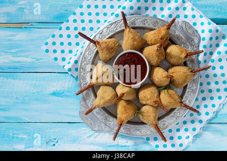 Snack frit épicé, jambes de caille escalope dans une pâte avec pané, sur la table de la cuisine. Le fast food. Banque D'Images