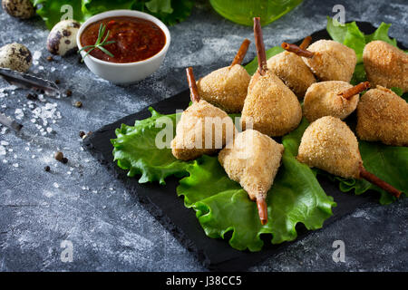 Snack frit épicé, jambes de caille escalope dans une pâte avec pané, sur la table de la cuisine. Le fast food. Banque D'Images