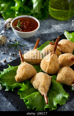 Snack frit épicé, jambes de caille escalope dans une pâte avec pané, sur la table de la cuisine. Le fast food. Banque D'Images