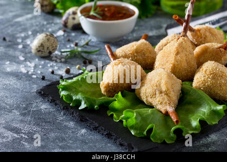 Snack frit épicé, jambes de caille escalope dans une pâte avec pané, sur la table de la cuisine. Le fast food. Banque D'Images