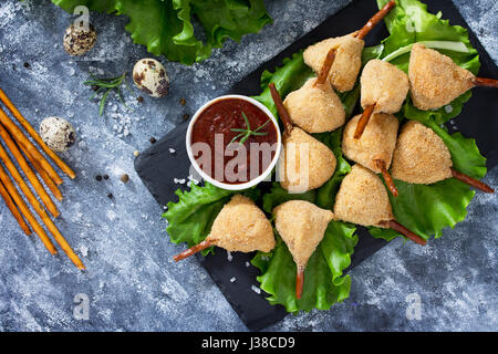 Snack frit épicé, jambes de caille escalope dans une pâte avec pané, sur la table de la cuisine. Le fast food. Banque D'Images