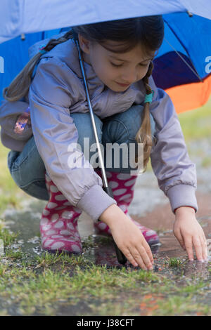 Fille avec un parapluie sous la pluie Banque D'Images