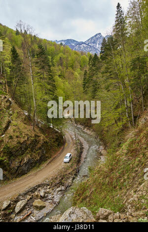 Vue aérienne d'un SUV voiture sur une route boueuse dans les montagnes Banque D'Images