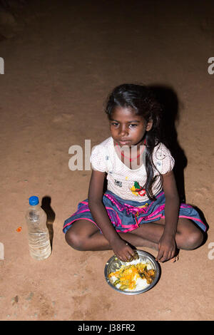 Film image éditoriale. Pondicherry, Tamil Nadu, Inde - le 24 avril 2014. Jeune fille très pauvres assis dans la rue, manger sur le sol lors de th Banque D'Images