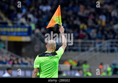Le joueur de football, arbitre de linesman, fait la vague du drapeau pour pointer un autre côté, au stade de san siro, à Milan. Banque D'Images