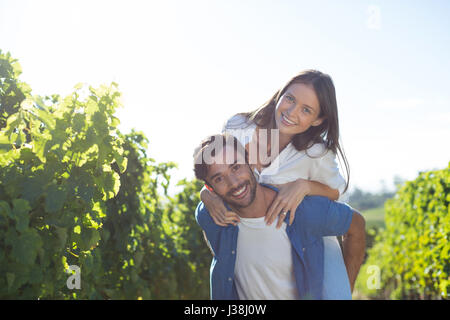 Portrait of happy young couple dos au vignoble au cours de journée ensoleillée Banque D'Images