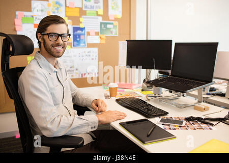 Portrait du designer sitting at desk in creative office Banque D'Images