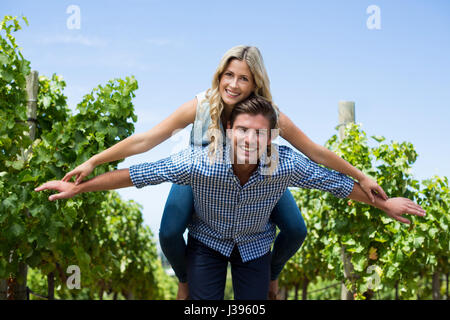 Portrait of happy young couple dos au vignoble contre le ciel bleu Banque D'Images