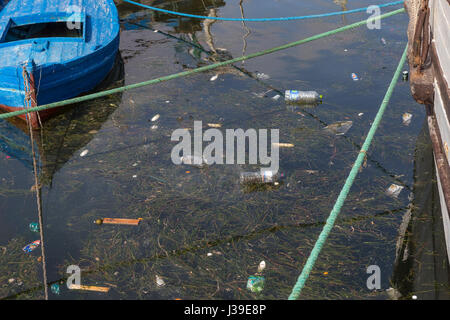 Notion de pollution : bateaux de pêche sur la plage de sale plein plastique trashes Banque D'Images