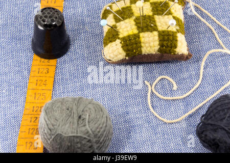 Tissu de jeans pour la couture,accessoires pour la couture sur nouveau jean arrière-plan. Tiroir de thread, ciseaux, dé, tapemeasure , fournitures de couture. Pour définir Banque D'Images