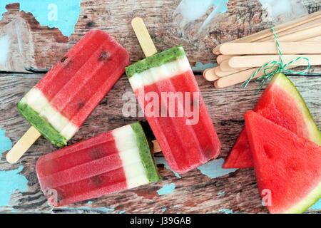 La glace de pastèque maison pop avec des tranches de melon contre fond de bois rustique Banque D'Images