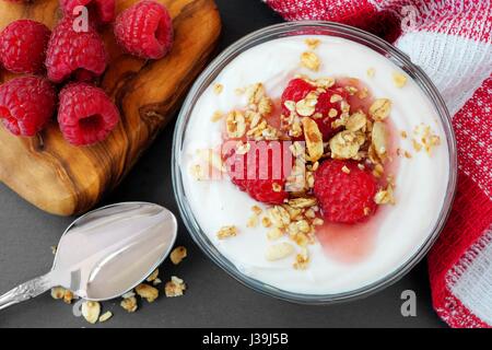 Yogourt grec à la framboise avec granola, scène de table frais généraux Banque D'Images