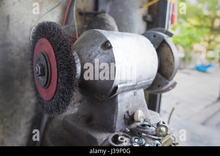 Brosse circulaire sur le fil machine de meulage. Polisseuse d'acier dans le garage. Banque D'Images