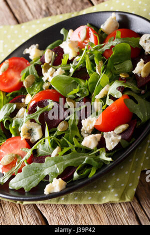 Betteraves à salade, roquette, tomates, fromage de Roquefort et graines de citrouille sur une plaque verticale. Banque D'Images